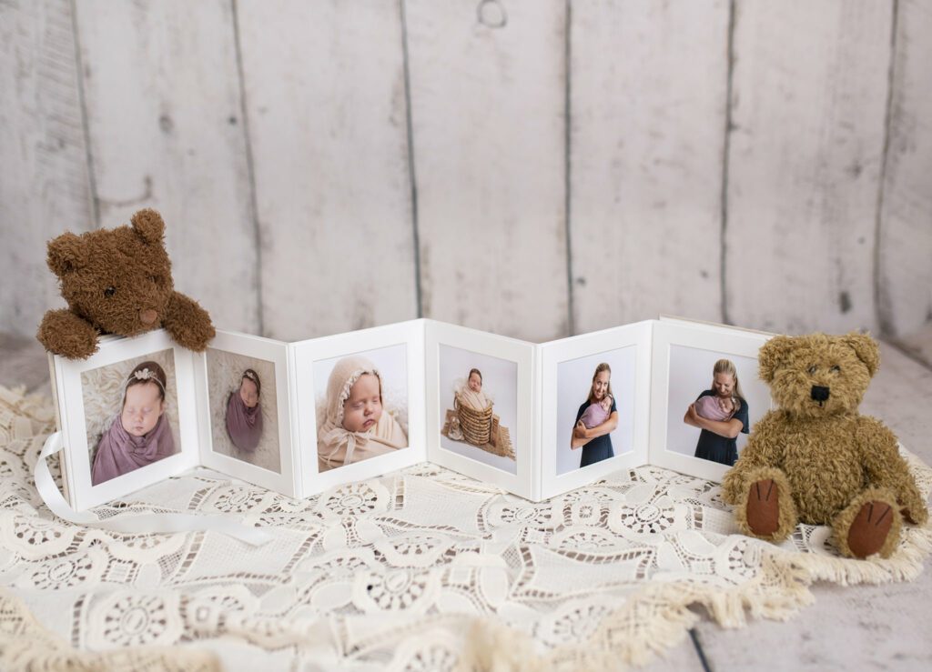 Babyfotografi med fotoalbum og bamser, barndomsminner og familie.