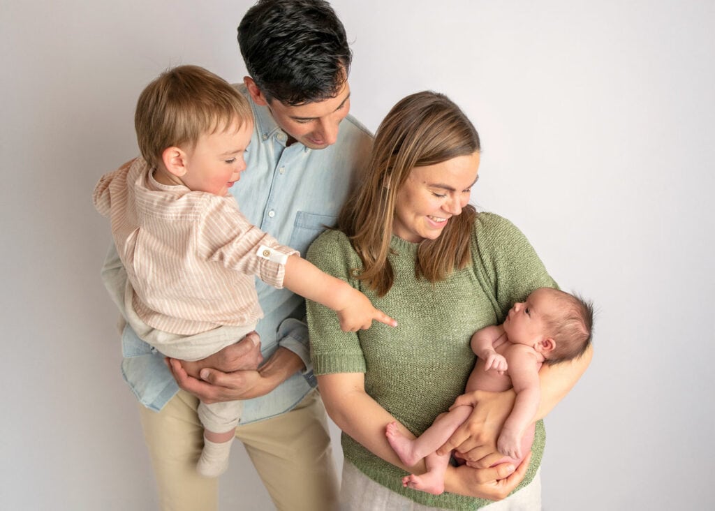 Familieportrett med nyfødt baby, småbarn og foreldre i fotostudio i Lillestrøm
