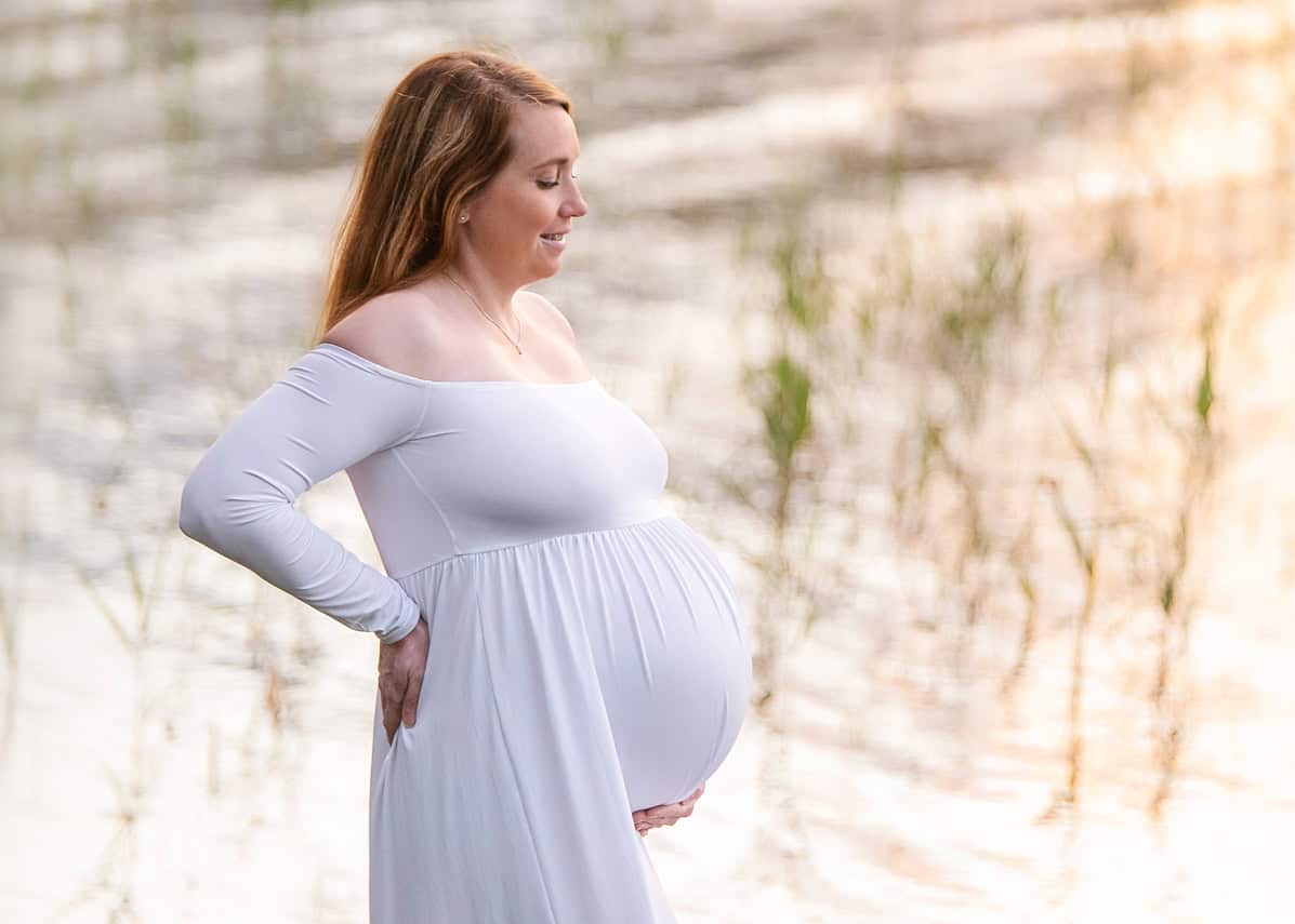 Gravidfotografering med hvit kjole ved en strand jessheim