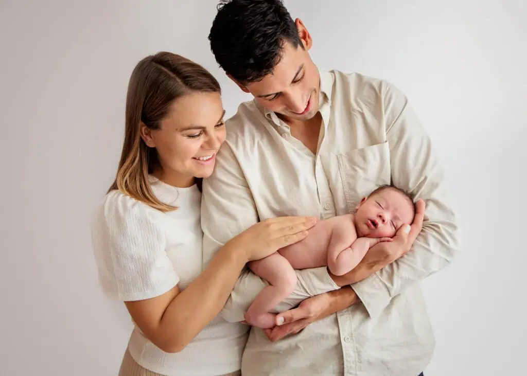Familieportrett med nyfødt baby og foreldre i fotostudio i Lillestrøm