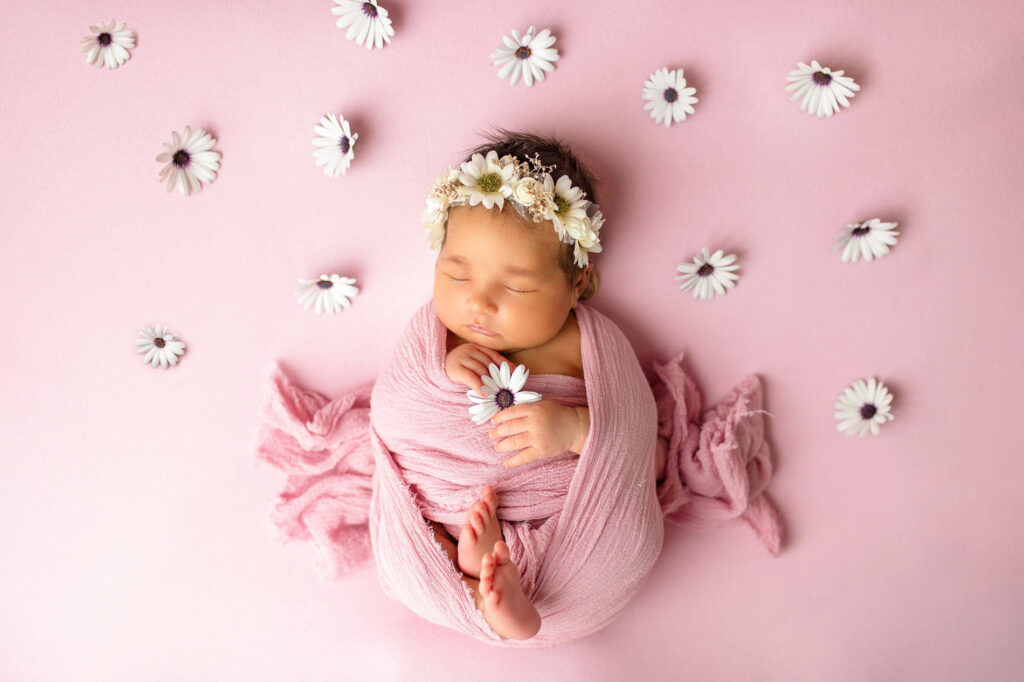 Baby med blomsterkrans og rosa stoff, nyfødtfotografering i Oslo.