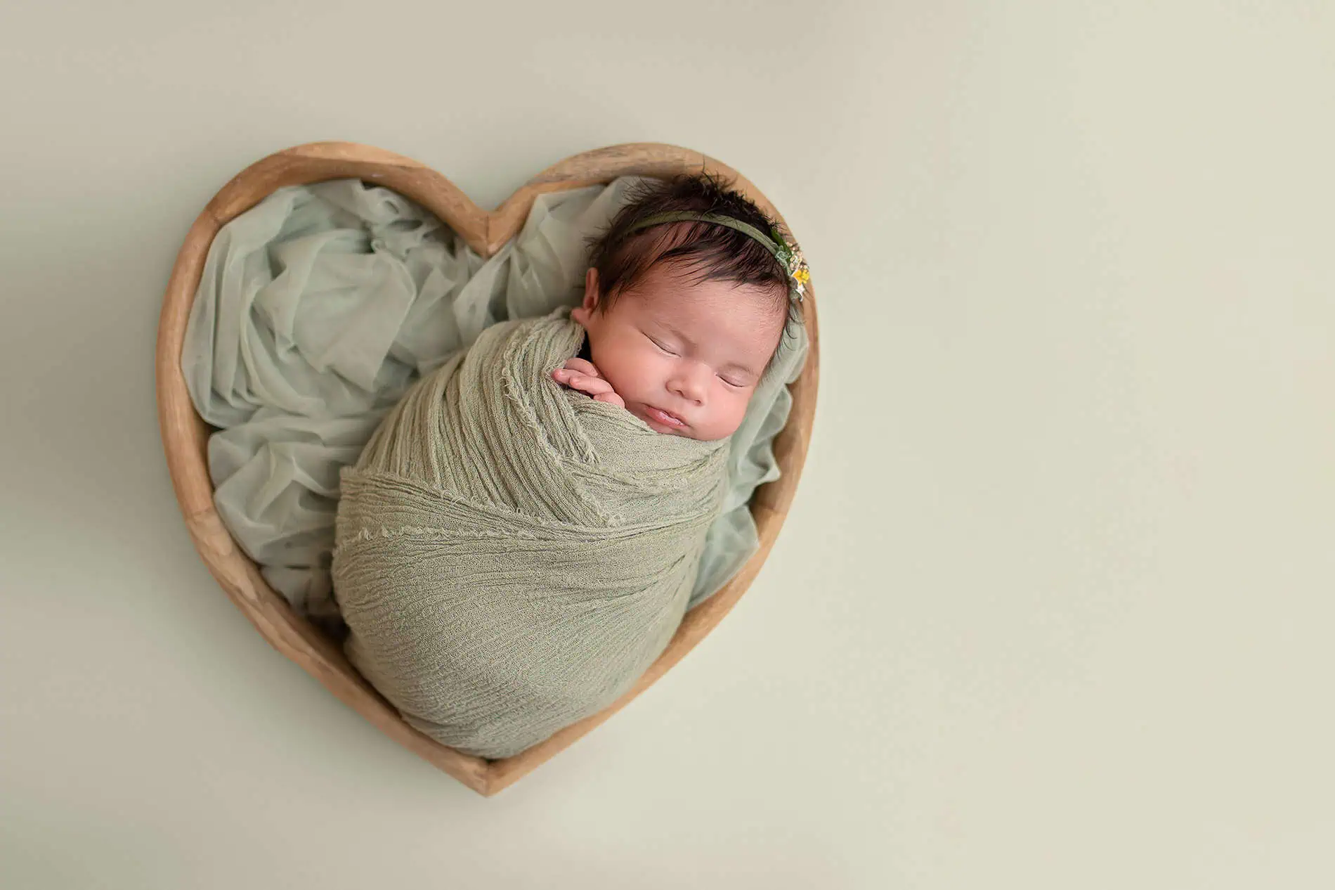 Nyfødt baby sovende i hjerteformet kurv, fotografi i Oslo.