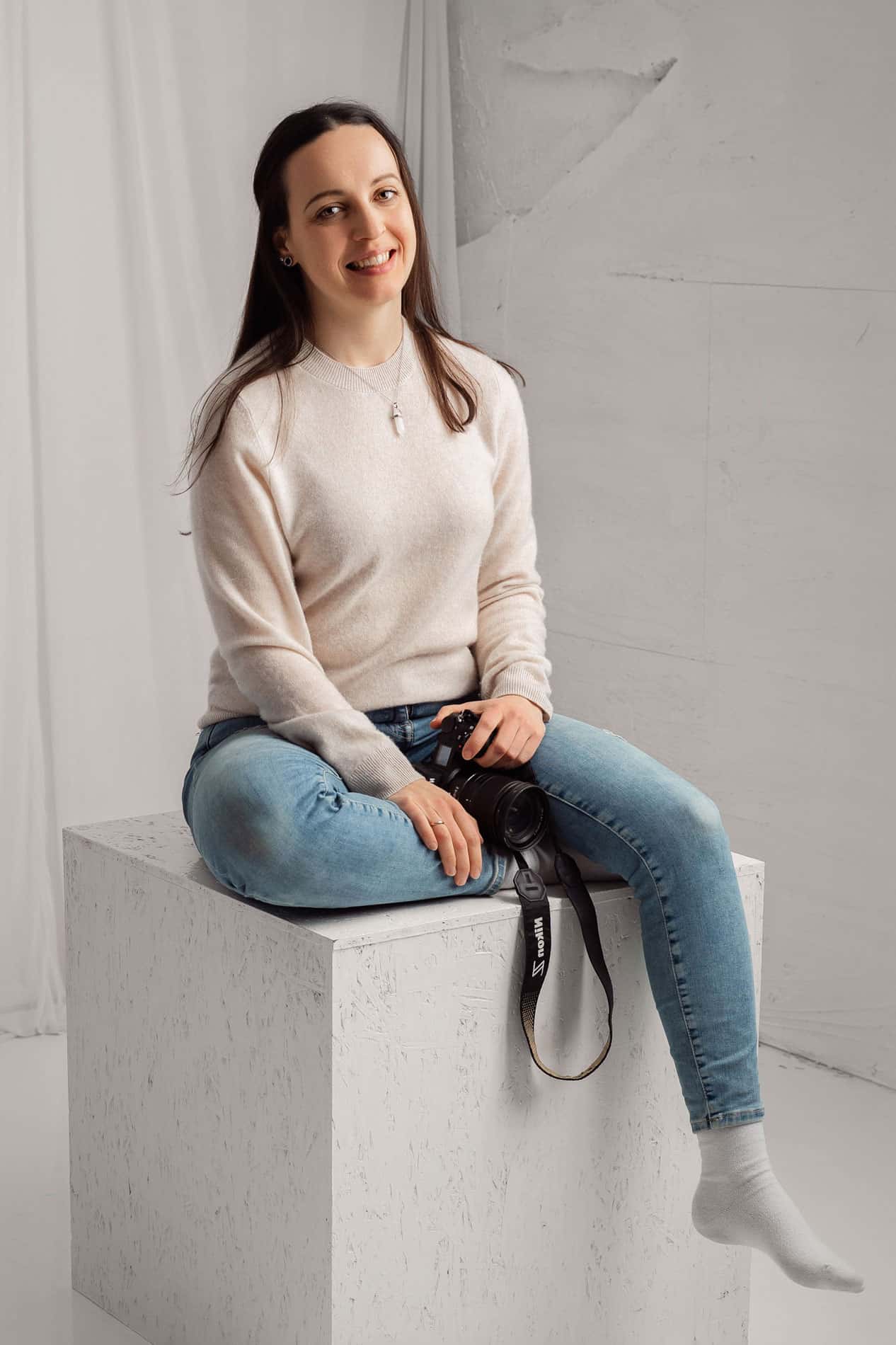 Profesjonell nyfødtfotograf Anna Carlsson med kamera, klar for nyfødtfotografering.